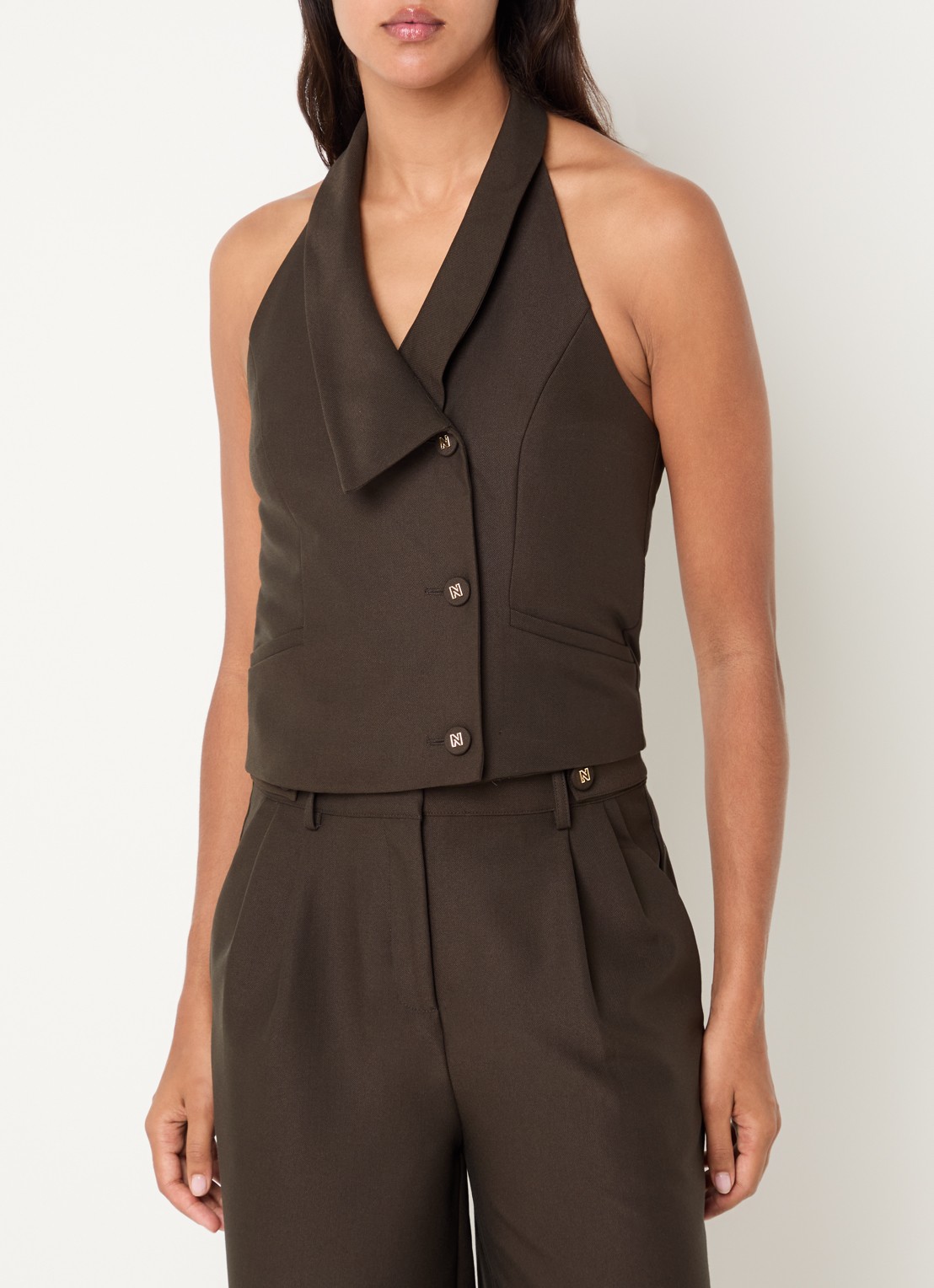NIKKIE Alani mouwloze blazer met paspelzakken - detail 4 bronsgroen