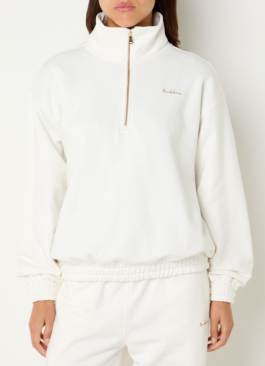 NIKKIE Avaleigh sweater met halve rits en logo - detail creme