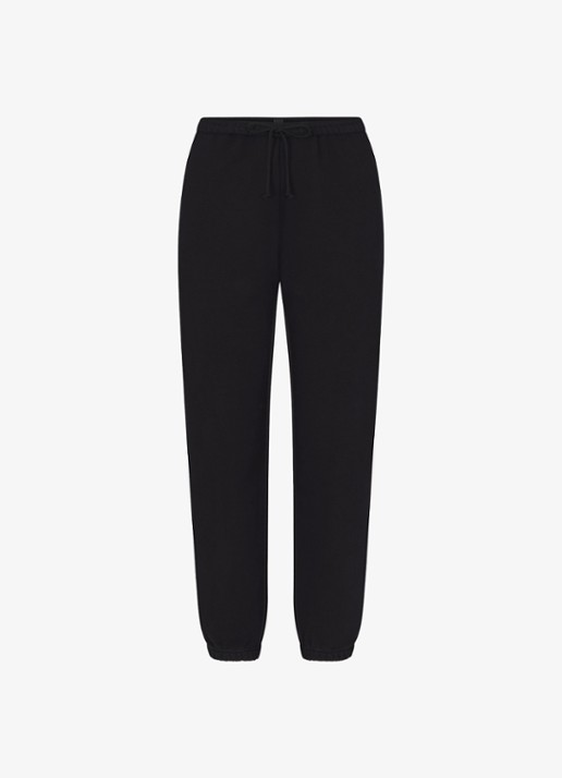 SKIMS Cotton Fleece mid waist tapered fit loungebroek met steekzakken - voorkant zwart